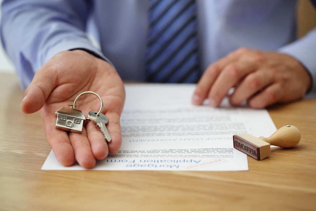 hand of real estate agent handing a home key